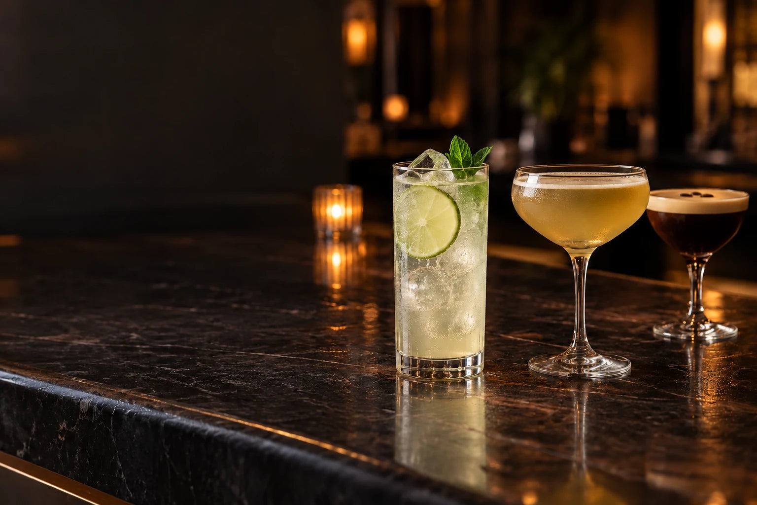 A lime highball, a golden coupe cocktail and an espresso martini in a warmly lit bar